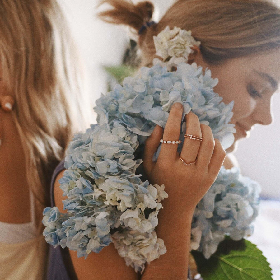 Girl holding blue flowers and wearing dainty rose gold rings - womens rose gold jewellery Australia