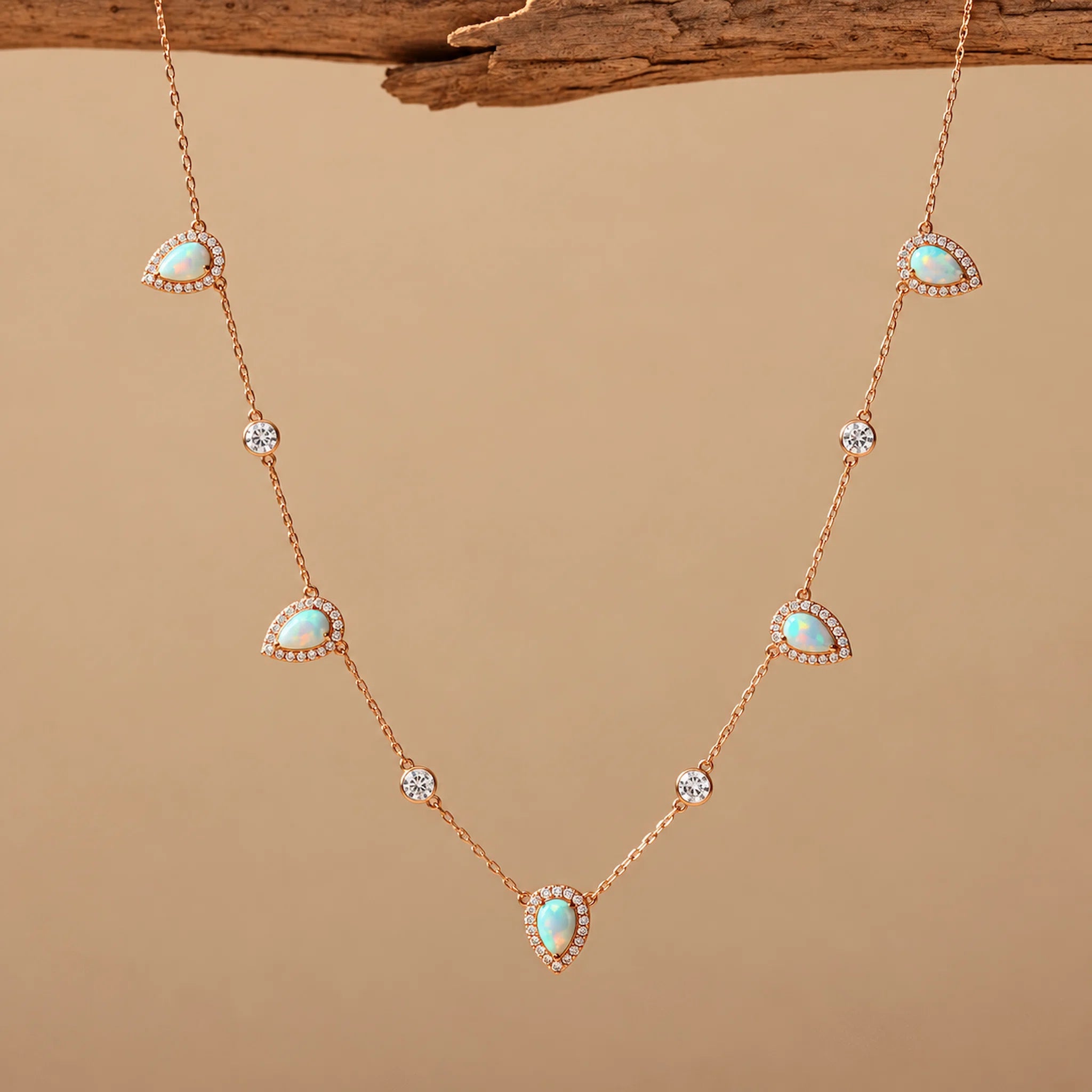 rose gold Necklace with opal and cz stones on a beige background