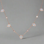 Rose gold necklace with opal stones on a gray background
