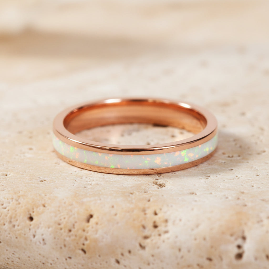 Rose gold ring with white opal interior on a light background