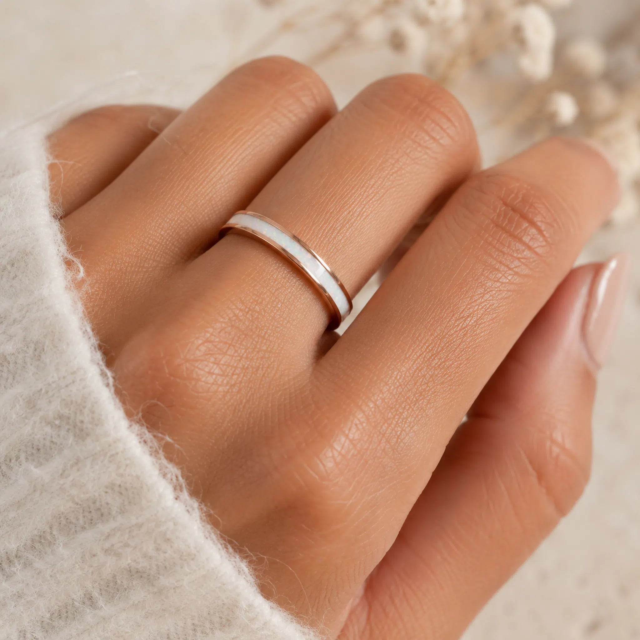 hand wearing a rose gold white opal inlay ring