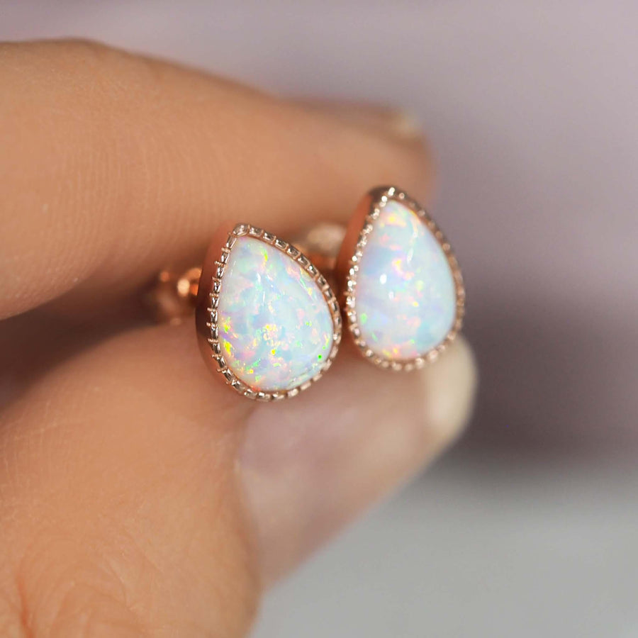 Fingers holding Rose Gold Opal Earrings - womens rose gold jewellery
