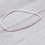 sterling silver Beaded bracelet with natural pink faceted rose quartz gemstones on a light wooden surface