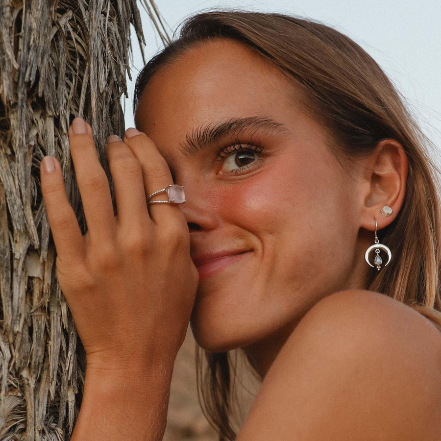 Woman leaning on a tree wearing Rose Quartz Ring - womens rose quartz jewellery by indie and harper