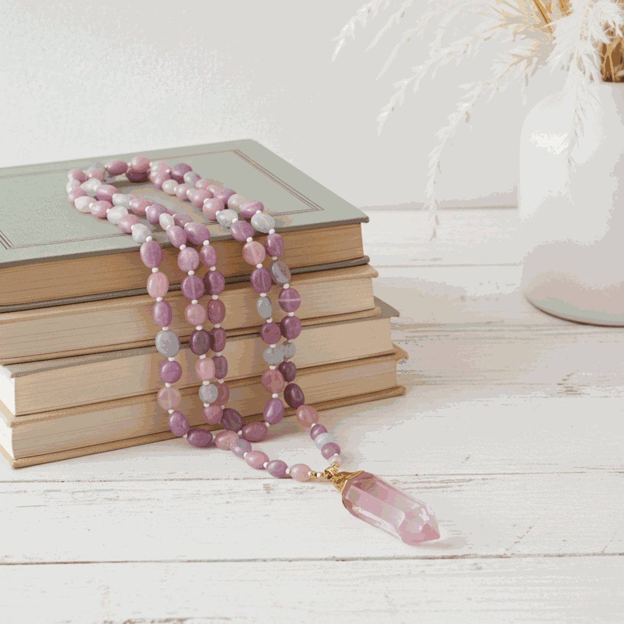 Beaded necklace with a pink pendant on a stack of books