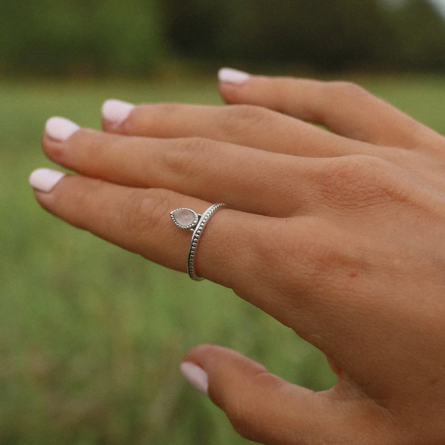 woman wearing sterling silver ring with one small teardrop petal shaped rose quartz stone
