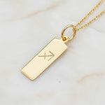 Sagittarius Zodiac Necklace in Gold Plated Sterling Silver laying on a light stone surface