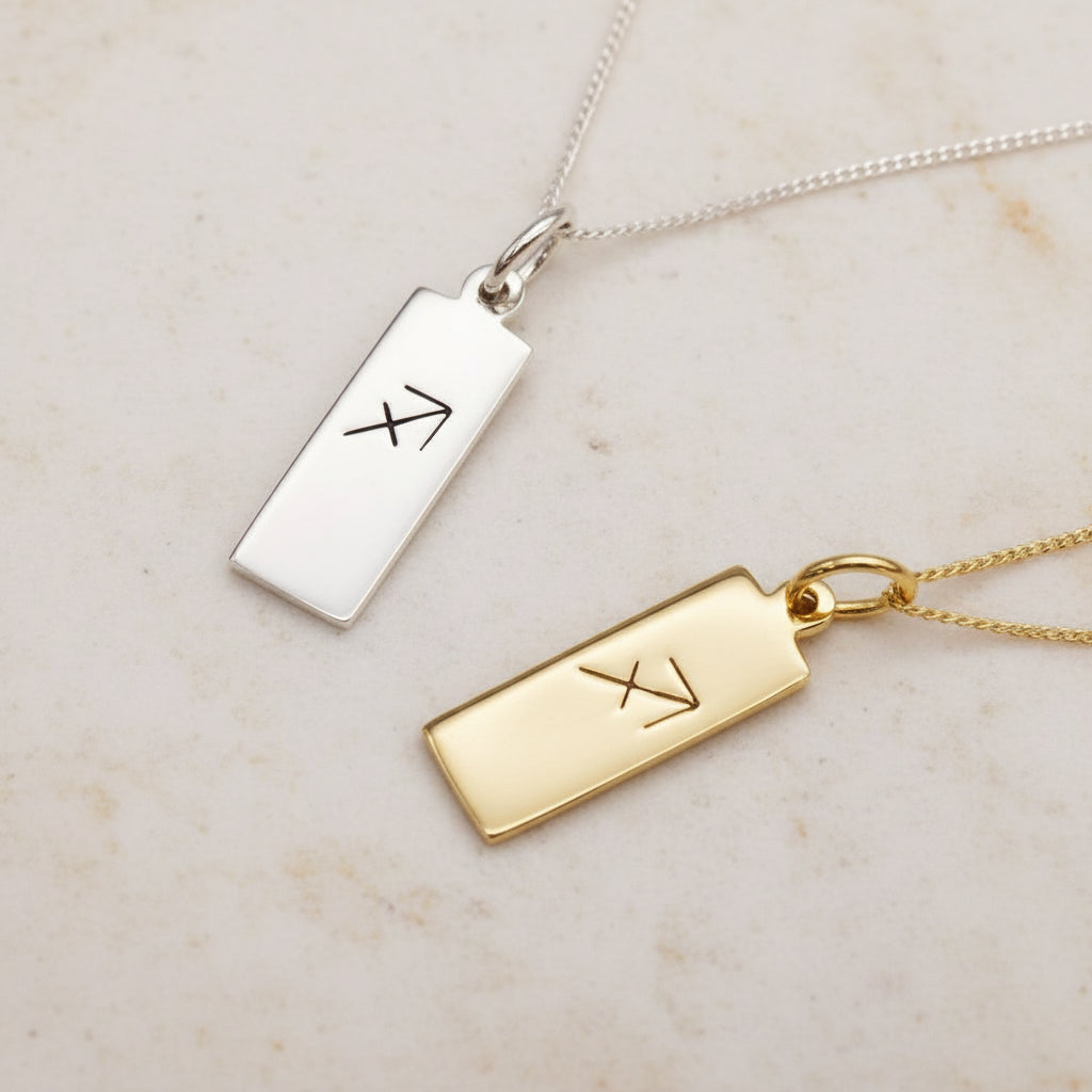 Sagittarius Zodiac Necklaces in Silver and Gold on a warm stone surface