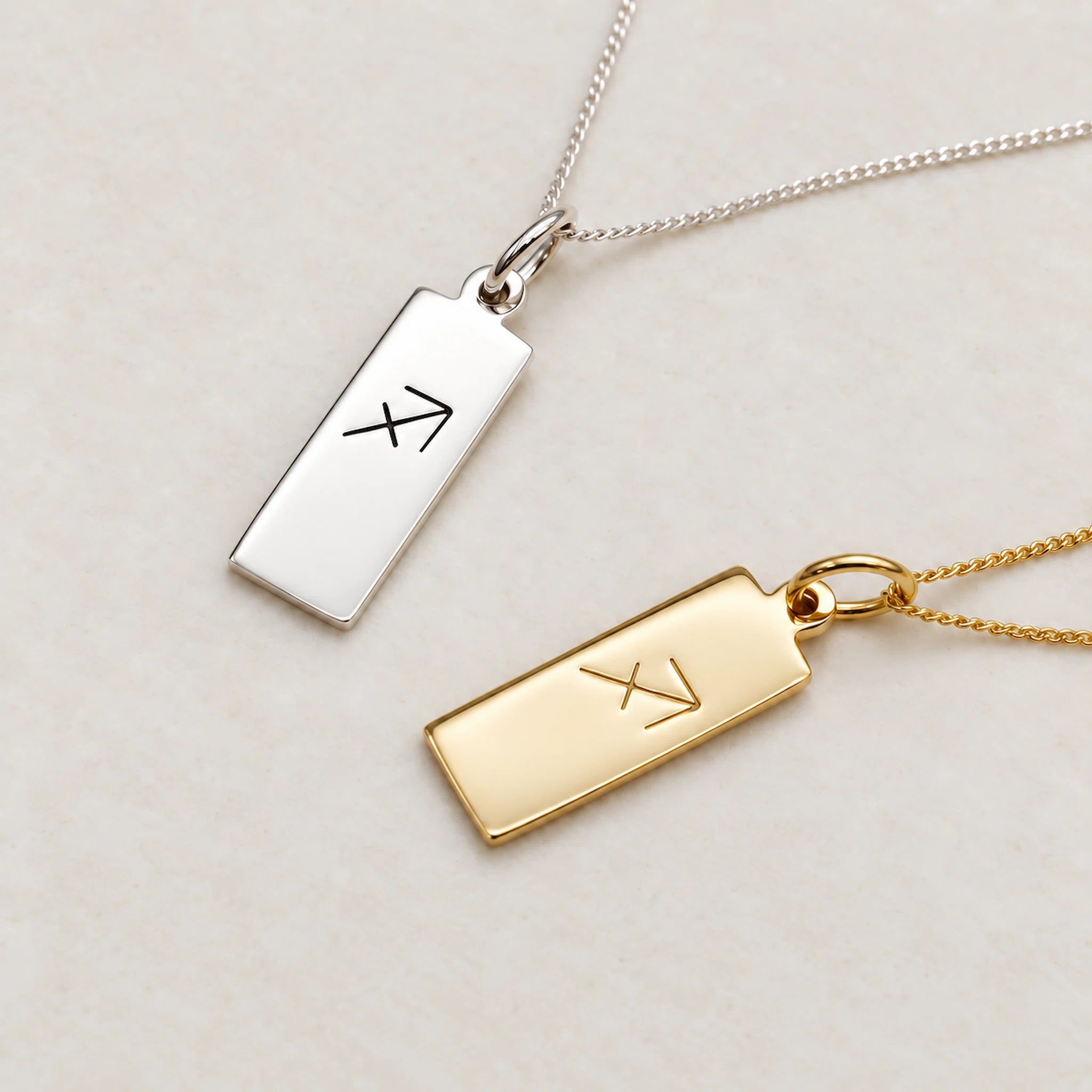 sterling silver and gold sagittarius necklace featuring rectangle pendant engraved with minimalist sagittarius zodiac star sign line glyph symbol suspended from a fine chain