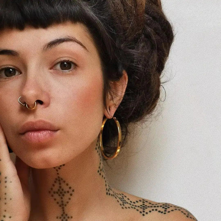 Woman with neck tattoos wearing large gold Hoop Earrings - waterproof jewellery by australian jewellery brand indie and harper