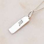 scorpio zodiac necklace in sterling silver laying on a light surface
