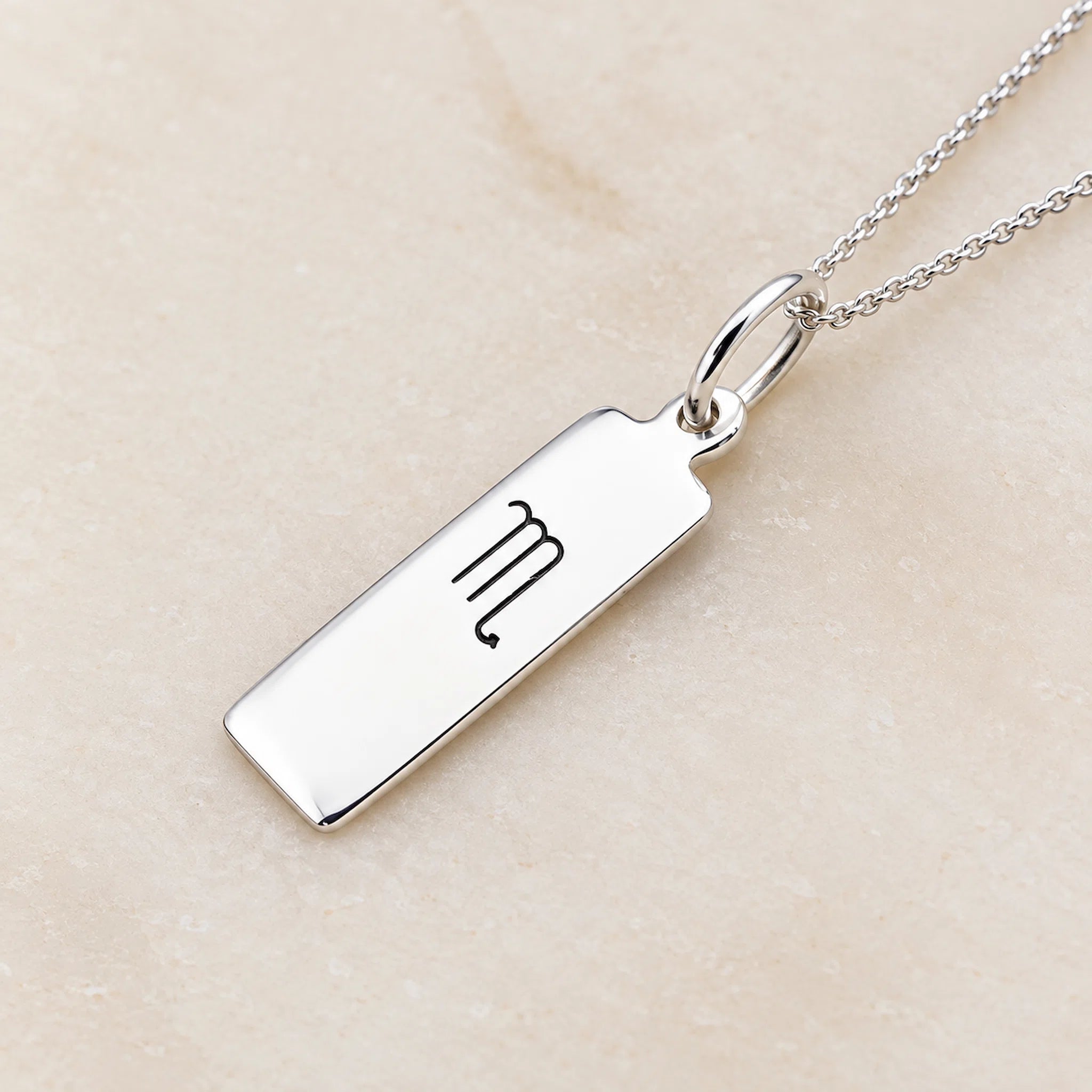 sterling silver scorpio necklace with rectangle pendant featuring engraved minimalist scorpio zodiac star sign line glyph symbol suspended from a fine chain