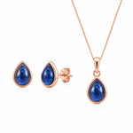 Rose gold september birthstone jewellery set featuring a teardrop-shaped pendant necklace and matching stud earrings with deep blue cabochon natural sapphire gemstones, displayed on a clean white background.