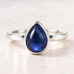 Sterling silver September birthstone natural sapphire ring on a matte white surface