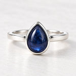 Front view of sterling silver September sapphire birthstone ring on a matte white surface