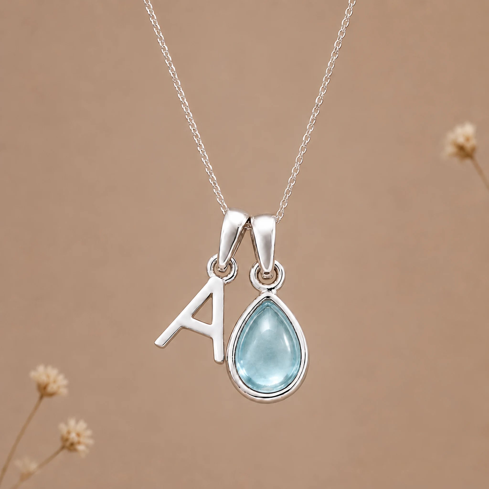 Sterling silver A initial necklace with pale blue March aquamarine in a polished teardrop bezel
