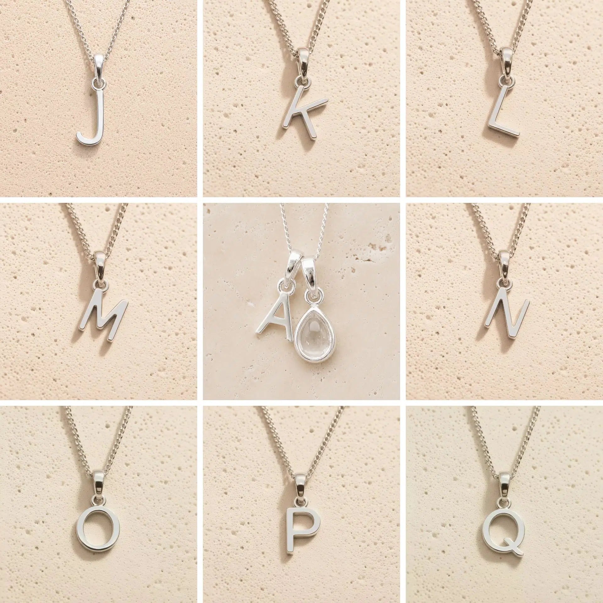 Collection of silver letter necklaces J to Q on a beige background as initial options for a personalised April Birthstone Clear Quartz Necklace.