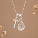 sterling silver initial t april birthstone natural clear quartz pendant necklace against a dark warm beige background