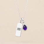 Sterling Silver necklace with a teardrop february birthstone natural amethyst pendant and engraved aquarius glyph tag hanging on a beige background.