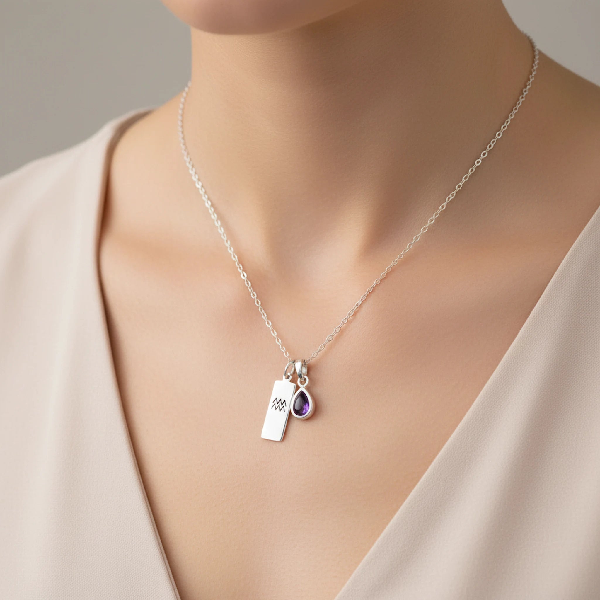 woman wearing a february birthstone amethyst and aquarius zodiac pendant necklace