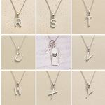 Collection of silver necklaces with various designs on a beige background