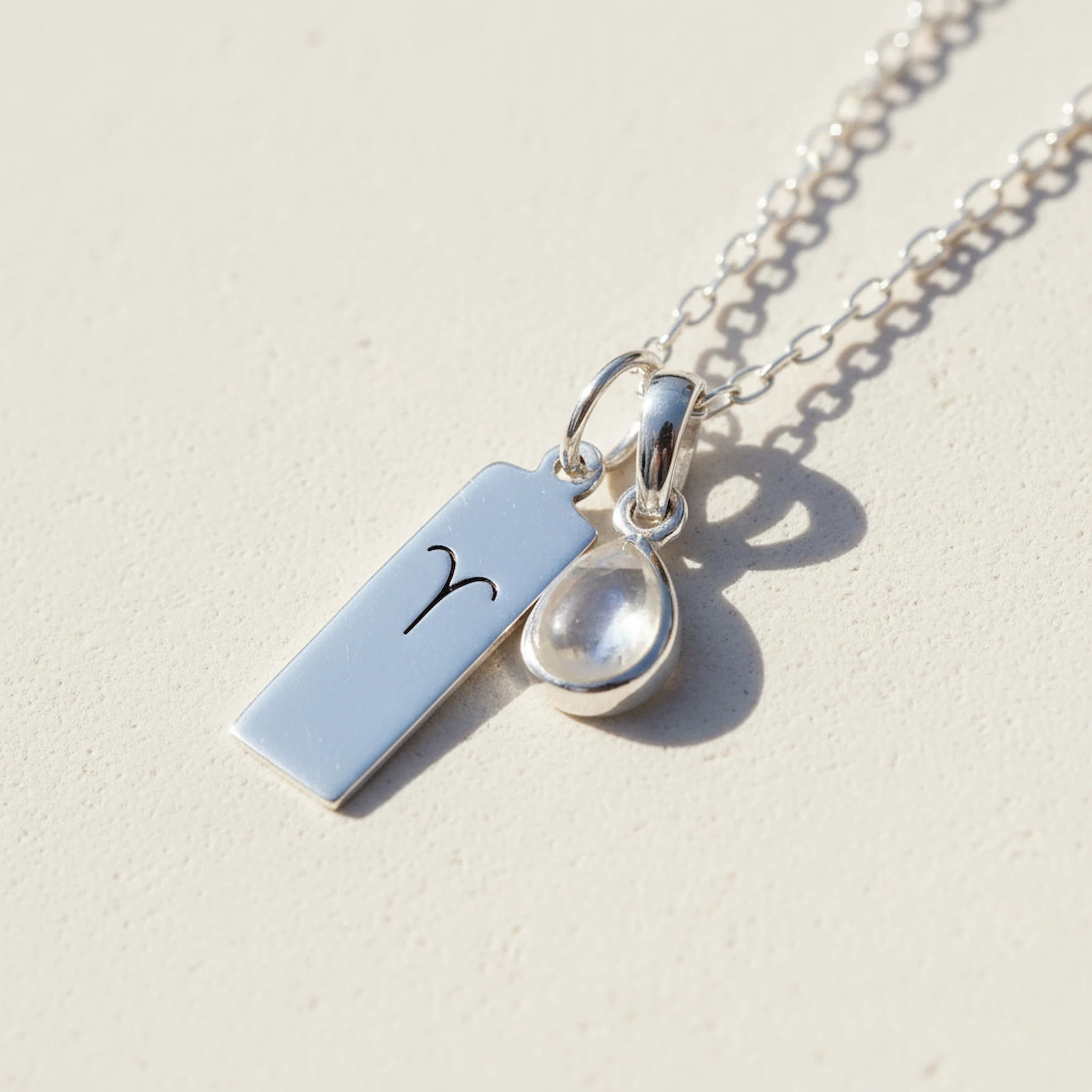 Sterling Silver April Birthstone necklace with a pear-shaped natural Herkimer Quartz pendant and a Aries zodiac pendant