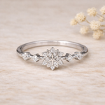 sterling Silver ring with snowflake design with cubic zirconias on a beige background