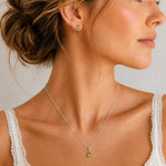 A woman wearing Sterling Silver August Birthstone Peridot Jewellery Set featuring natural peridot earrings and matching peridot necklace.