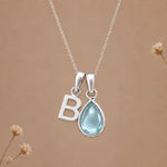 Sterling silver B initial necklace with pale blue March aquamarine in a polished teardrop bezel