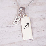 sterling silver necklace with a 'B' initial pendant and a sagittarius zodiac pendant on a light background