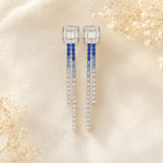 Elegant earrings with blue gemstones on a soft beige background