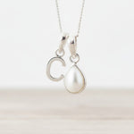 Sterling Silver necklace with 'C' initial pendant and teardrop-shaped mother of pearl charm on a light background