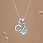 Sterling silver C initial necklace with pale blue March aquamarine in a polished teardrop bezel
