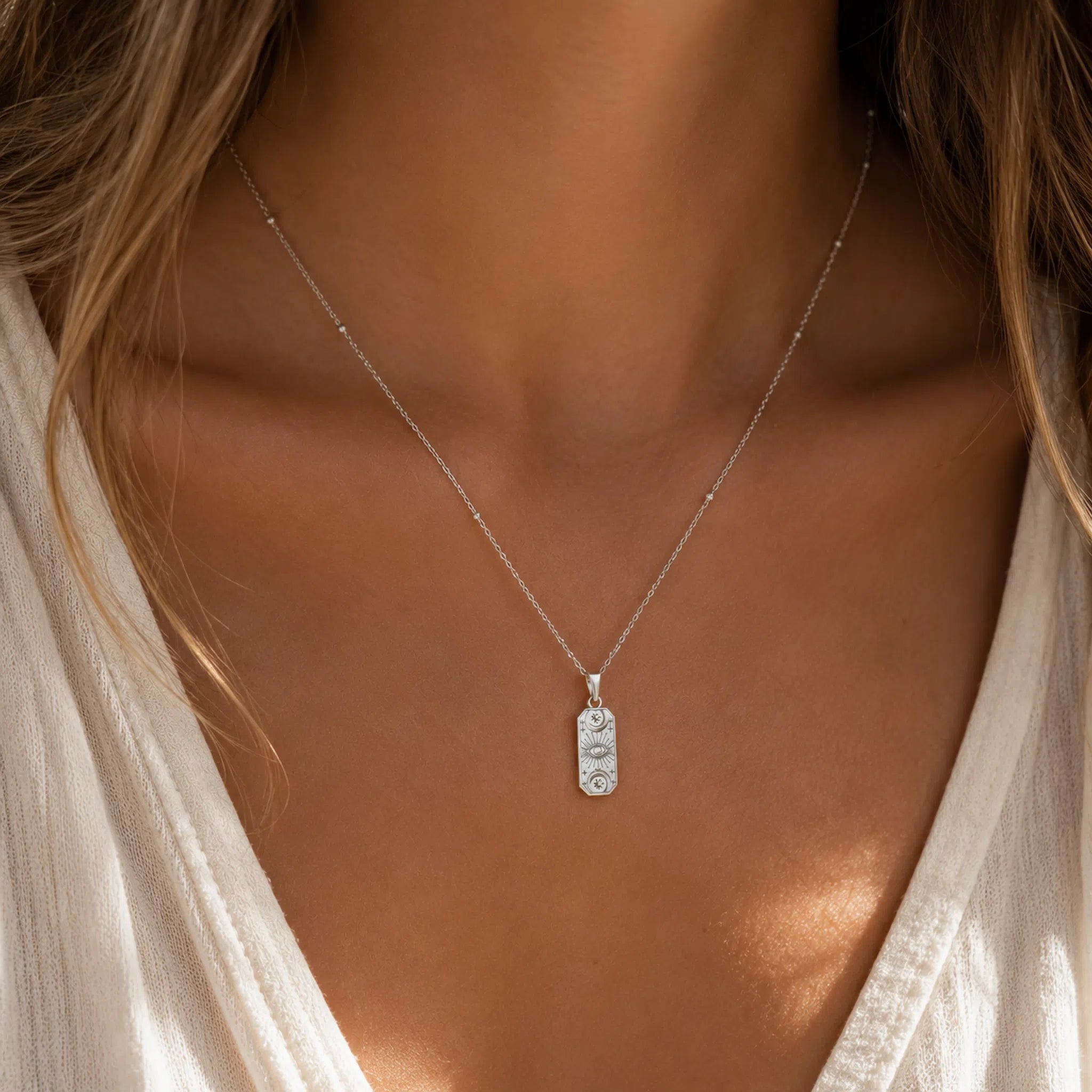 model wearing a silver celestial charm pendant necklace
