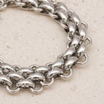 Close-up of a waterproof silver chunky chain bracelet on a light beige background