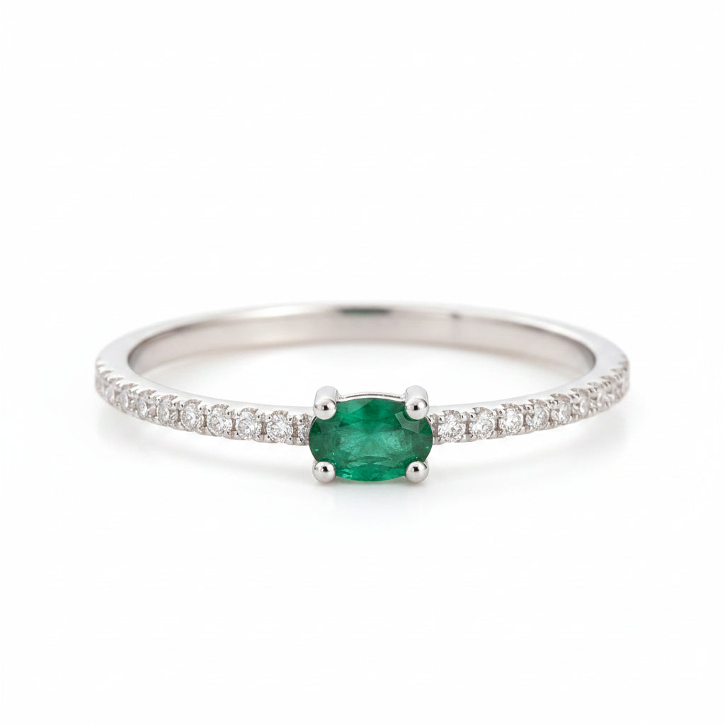 Classic Sterling Silver natural emerald ring - CZ Pave Stacking ring with a oval faceted claw set emerald gemstone on a beige background.