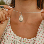 woman wearing wsterling silver cowrie shell necklace