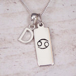 Sterling Silver D Initial Cancer Zodiac Star Sign Necklace on a fine silver chain against a light wooden background