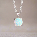 Opal pendant necklace on a chain against a neutral background