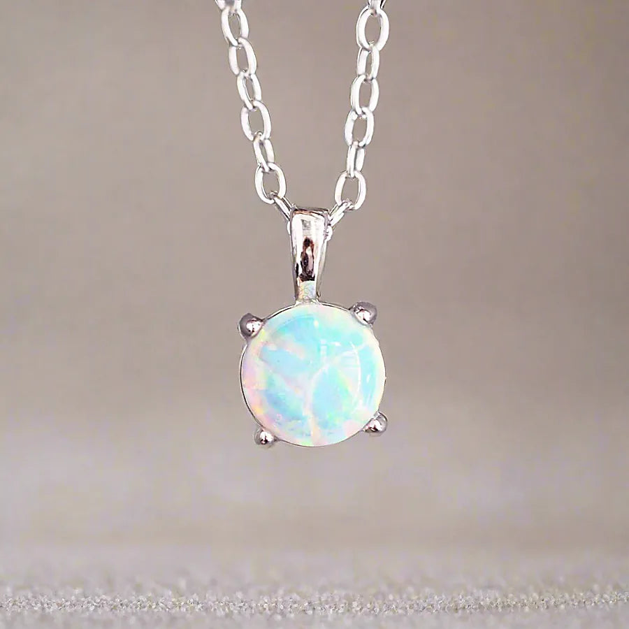Opal pendant necklace on a chain against a neutral background