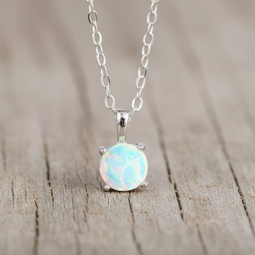 Opal pendant necklace on a chain against a neutral background