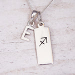 sterling silver necklace with a 'E' initial pendant and a sagittarius zodiac pendant on a light background
