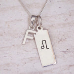 sterling silver initial f leo zodiac star sign pendant necklace against a light wooden background