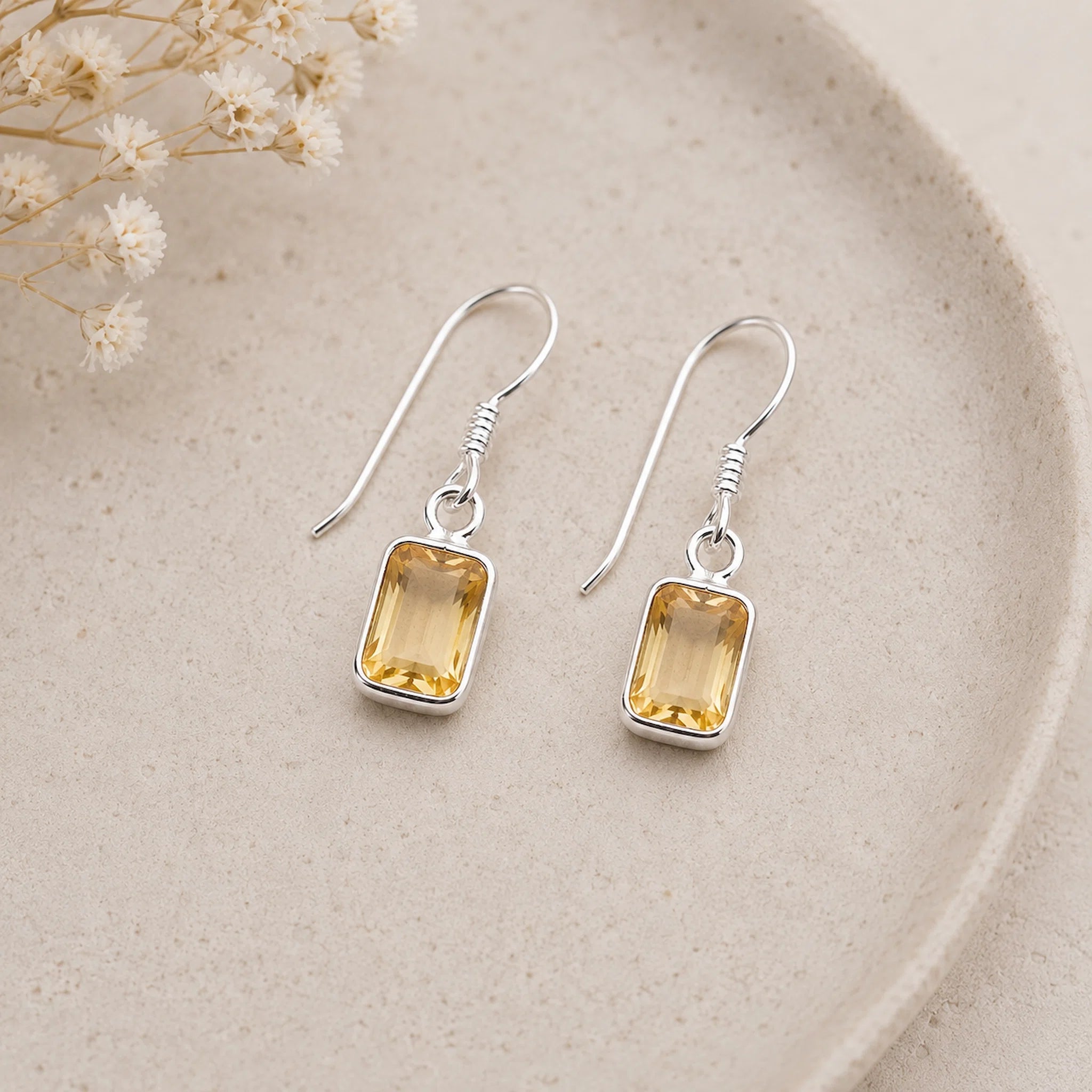 pair of sterling silver french hook earrings with bezel set emerald-cut natural citrine gemstones