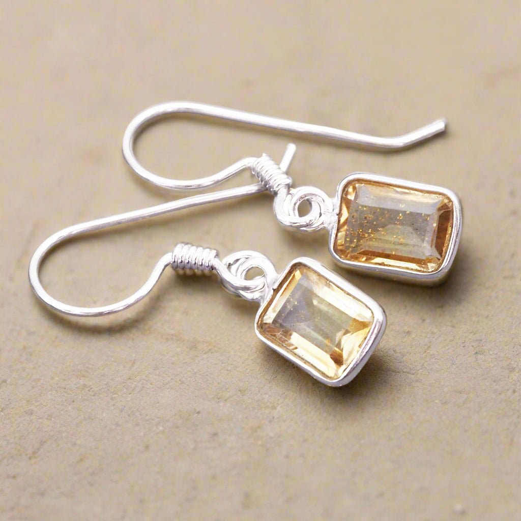 sterling silver french hook earrings with natural citrine gemstones laying on a light surface