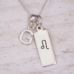 sterling silver initial g leo zodiac star sign pendant necklace against a light wooden background