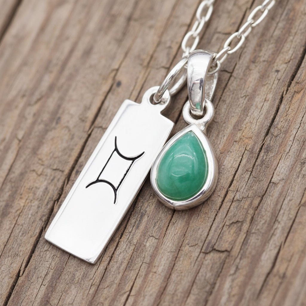 silver zodiac Gemini and may Birthstone emerald Necklace on a wooden surface by indie and harper australia