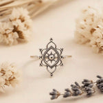 Silver ring with star design on a beige background with flowers
