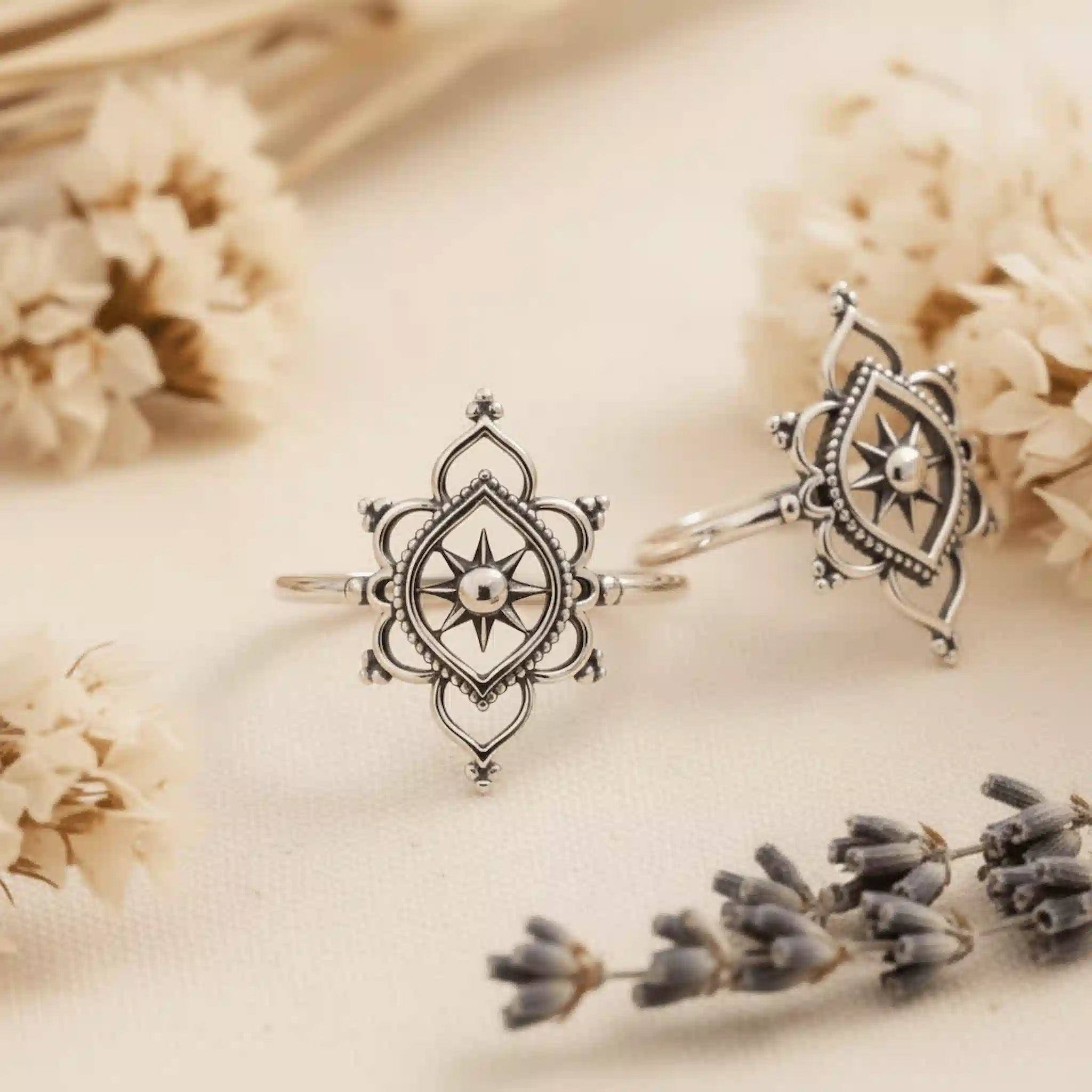 two sterling silver rings with intricate mandala type design