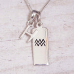 Sterling Silver H Initial and Aquarius Necklace on a fine silver chain against a light wooden background